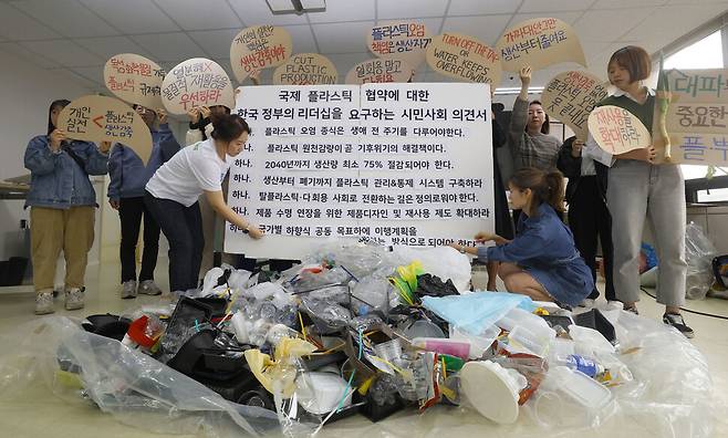 플라스틱 문제를 뿌리 뽑는 연대 회원들이 15일 오전 서울 용산 그린피스 사무실에 쌓아놓은 플라스틱 쓰레기 앞에서 정부에게 하고 싶은 말이 적힌 말풍선을 들고 있다. 윤운식 선임기자 yws@hani.co.kr