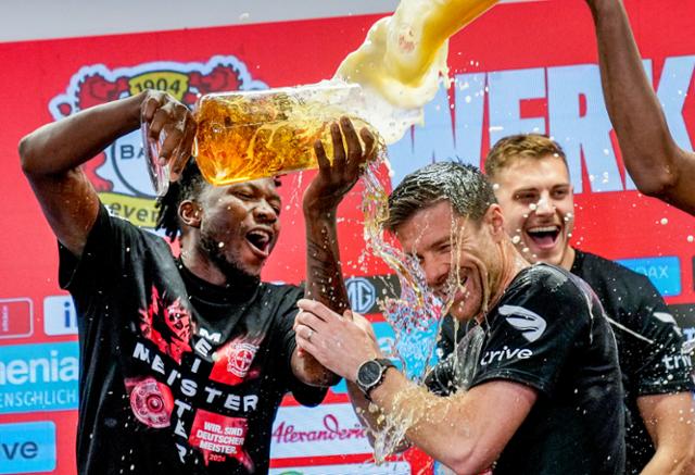 레버쿠젠의 사비 알론소(가운데) 감독이 14일(현지시간) 독일 레버쿠젠의 바이아레나에서 열린 2023~24시즌 독일 분데스리가 29라운드에서 리그 우승을 확정한 뒤 선수들로부터 맥주 세례를 받고 있다. 레버쿠젠=AP 뉴시스