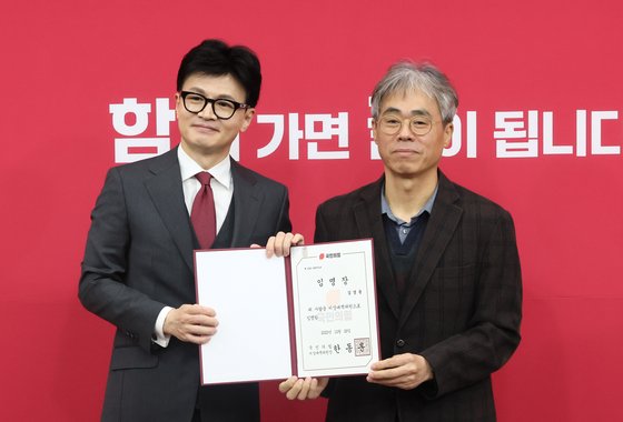 한동훈 당시 국민의힘 비상대책위원장이 지난해 12월 29일 국회에서 열린 비상대책위원 임명장 수여식에서 김경률 비대위원에게 임명장을 수여한 뒤 포즈를 취하고 있다. 연합뉴스