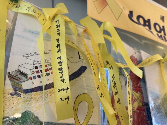 Yellow ribbons, used commonly to express sympathy and condolences for the victims of the Sewol ferry disaster, are tied to a rope at the Sewol ferry memorial space at Jindo Port in Jindo, South Jeolla Province. One ribbon in the photo reads: "I'm sorry for not being able to protect you." (Lee Jung-joo/The Korea Herald)