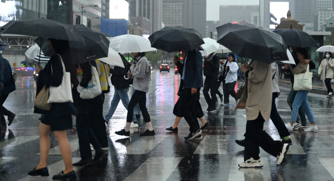 비오는 월요일 출근길 전국 곳곳에 봄비가 내린 15일 오전 서울 종로구 세종대로 사거리에서 출근길에 시민들이 우산을 쓰고 횡단보도를 건너가고 있다.  문호남 기자
