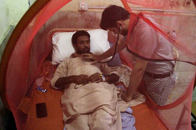 파키스탄 페샤와르의 한 지역병원 격리병동에서 뎅기열을 앓고 있는 환자가 치료를 받고 있는 모습. [EPA]
