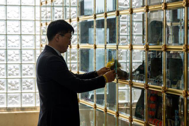 지난달 16일 경기 평택시 서호추모공원을 찾은 장훈이 아들의 유골함 앞에 붙은 꽃을 매만지며 생각에 빠져 있다. 평택=박시몬 기자