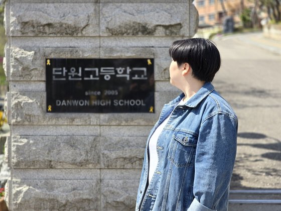 세월호 참사 단원고 생존자 유가영(27)씨가 경기 안산 단원고 정문 앞에서 학교 명패를 바라보고 있다. 손성배 기자