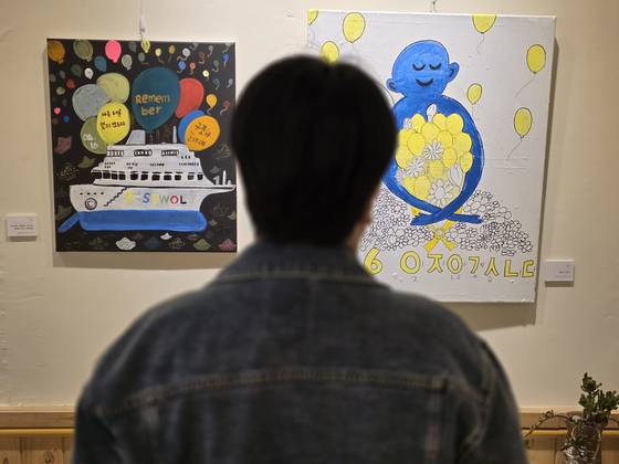 Yu Ga-young, a survivor of the Sewol ferry tragedy, looks at art pieces displayed at the exhibition hall of the center commemorating the victims of the Sewol ferry disaster. [SON SUNG-BAE]