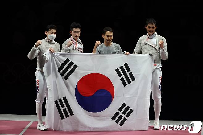 펜싱 오상욱, 구본길, 김정환, 김준호가 28일 일본 지바 마쿠하리 메세 B홀에서 열린 '2020 도쿄올림픽' 펜싱 남자 사브르 단체 결승전 이탈리아와의 경기에서 승리한 뒤 태극기를 들고 있다. 2021.7.28/뉴스1 ⓒ News1 송원영 기자