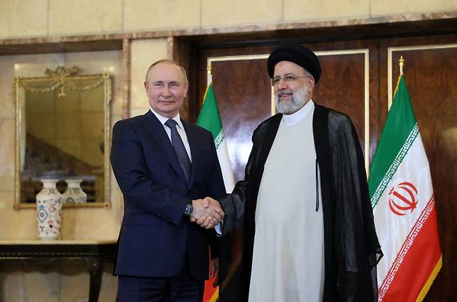 2022년 7월19일(현지시간) 블라디미르 푸틴 러시아 대통령(왼쪽)과 에브라힘 라이시 이란 대통령이 이란 테헤란에서 회담을 진행하기에 앞서 악수를 하고 있다. 로이터연합뉴스