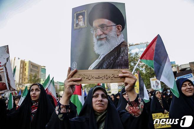 이스라엘이 이란의 공습을 받은 다음 날인 15일(현지시간) 한 이란 여성이 아야톨라 알리 하메네이 이란 최고지도자의 사진을 들고 거리로 나서고 있다. 2024.04.15 ⓒ AFP=뉴스1 ⓒ News1 정지윤 기자