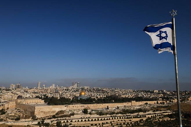 19일 이스라엘 예루살렘에 있는 올리브산에 이스라엘 국기가 펄럭이고 있다. 이날 이스라엘이 이란에 대한 재보복에 나서면서 중동 정세의 변동성이 확대되며, 우리나라 수출에 타격이 우려된다./AFP연합뉴스