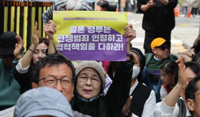 시민들이 17일 서울 종로구 수송동 옛 일본대사관 앞 평화의 소녀상 인근에서 열린 일본군 성노예제 문제 해결을 위한 정기 수요시위에 참석해 피켓을 들어 보이고 있다. 뉴시스