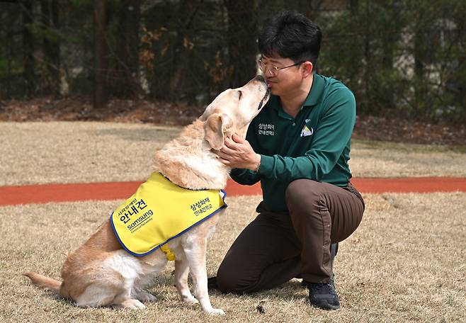 Park Tae-jin pets 6-year-old trained dog Genie at Samsung Guide Dog School in Yongin, Gyeonggi Province, March 27. (Im Se-jun/ The Korea Herald)