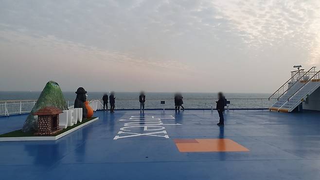 2021년 12월21일 제주로 향하는 하이덱스스토리지㈜의 ‘비욘드 트러스트(Beyond trust·2만7000t급)’호 갑판에 승객들이 올라와 아침 바다 풍경을 감상하고 있다.