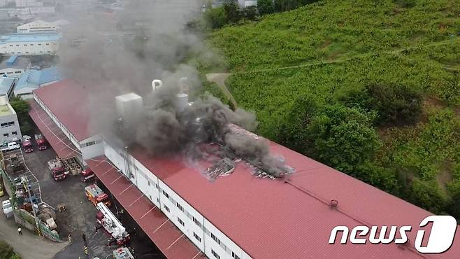 불이 난 폐기물 처리업체 건물 지붕을 뚫고 나오는 연기.(경남소방본부 제공)