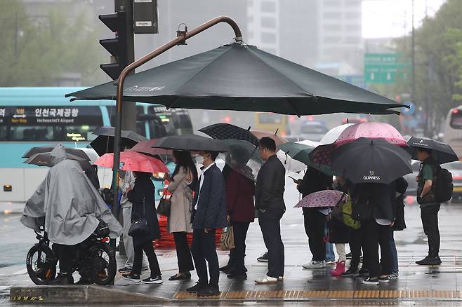 지난 16일 오전 서울 종로구 세종대로 사거리에서 출근길 시민들이 우산을 쓰고 있다./뉴스1