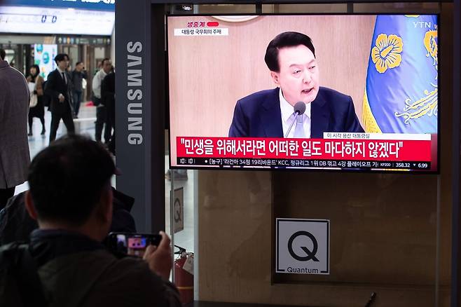 지난 16일 서울역에서 한 시민이 윤석열 대통령 주재 국무회의 생중계를 휴대전화 카메라로 촬영하고 있다./ 사진=뉴스1