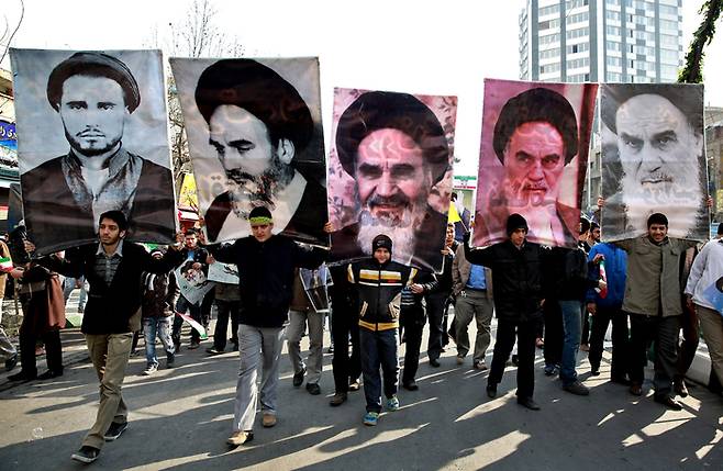 지난 2014년, 친미 팔레비 왕정을 무너뜨린 이란 이슬람 혁명 35주년 기념 집회에서 청소년들이 ‘혁명의 아버지’ 아야톨라 루홀라 호메이니의 초상화들을 어깨에 메고 있다. /사진=연합뉴스