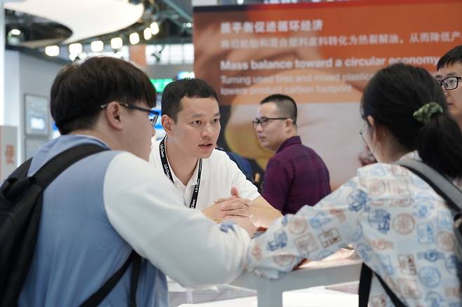 지난해 4월 중국 선전에서 열린 ‘차이나플라스 2023’에서 LG화학 직원이 고객에게 제품을 설명하고 있는 모습. [사진출처 = LG화학]