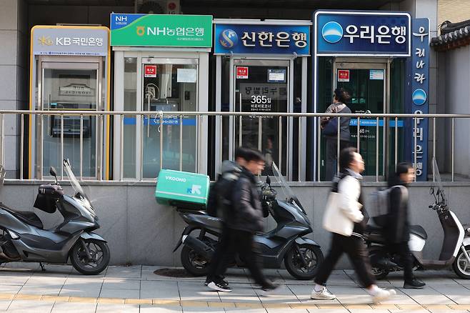 서울 시내에 설치된 시중은행 ATM 기기 앞을 시민들이 지나가고 있다. /뉴스1