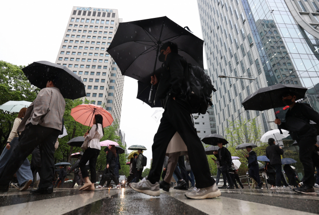 ▲비가 내린 지난 15일 오전 서울 영등포구 여의도역 인근에서 시민들이 우산을 쓰고 이동하고 있다. ⓒ연합뉴스
