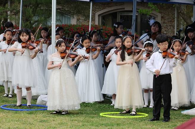 포항 호텔 영일대 호수공원에서 진행된 ‘찾아가는 클래식 영일대 블라썸 연주회’에서 스즈키바이올린 원생 30여 명이 바이올린 연주를 진행하고 있다.