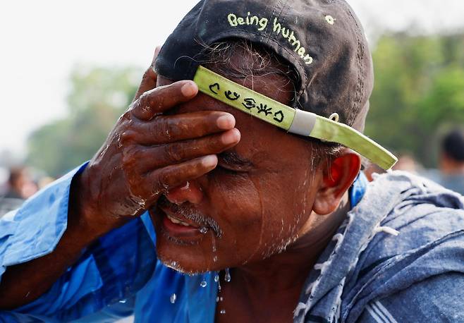 지난 16일 인도 콜카타에서 한 남성이 더위를 식히려 얼굴을 물로 닦고 있다./로이터 연합뉴스