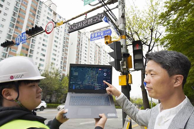 LG유플러스 관계자가 천안시에 설치된 긴급차량 출동 알림 전광판을 점검하는 모습.