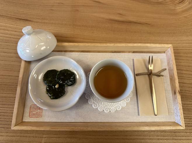Jingwansa’s "dado" experience, also known as a tea ceremony, includes tea with mugwort flavored tteok, or Korean rice cakes. (Lee Jung-joo/The Korea Herald)