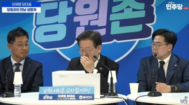 이재명(가운데) 더불어민주당 대표가 지난 19일 서울 여의도 민주당사에서 진행된 당 공식 유튜브 채널 '당원과의 만남'에서 당원의 메시지를 읽다 입을 가렸다. [유튜브 더불어민주당 채널]