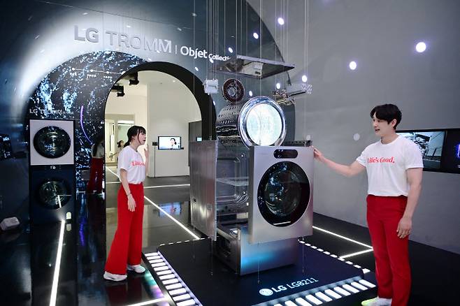 서울 코엑스에서 열리는 월드IT쇼 2024에서 LG전자 모델들이 올인원 세탁건조기 ‘LG 시그니처 세탁건조기’의 ‘AI DD모터’와 ‘인버터 히트펌프’ 등 핵심 부품을 살펴보고 있다. (사진=LG전자)