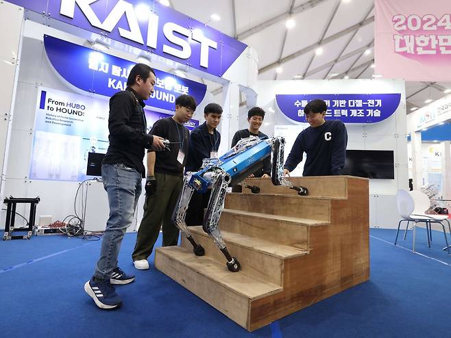 한국과학기술원(KAIST) 부스에서 기계공학과 연구원들이 4족보행 로봇 하운드를 작동하고 있다./KAIST