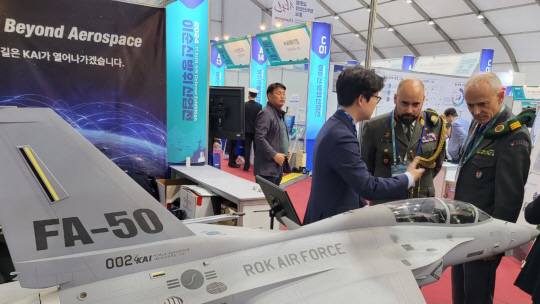 24일부터 경남 진해·창원 해군사관학교에서 열리고 있는 2024 이순신 방위산업전(YIDEX)  한국항공우주산업(KAI) 부스를 방문한 오스트리아, 스위스 국방무관이 다목적 전투기 FA-50에 대한 설명을 듣고 있다. 한국항공우주산업 제공