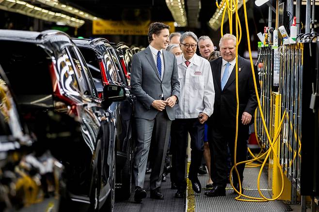 25일(현지시간) 캐나다 온타리오주 엘리스턴에서 혼다 CEO 미베 도시히로가 쥐스텡 트뤼도 캐나다 총리와 공장을 둘러보고 있다. [로이터]