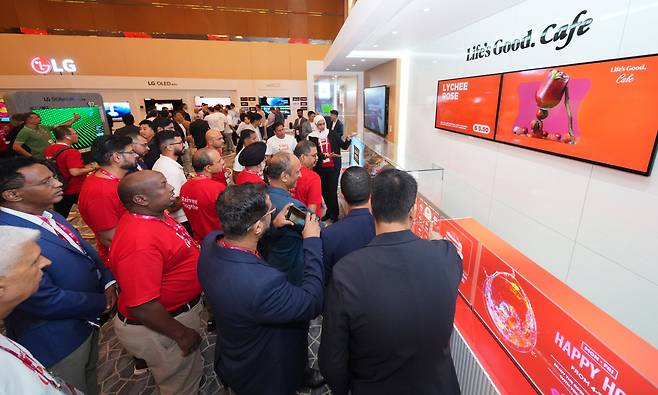LG전자가 아랍에미리트(UAE) 아부다비에서 진행한 ‘LG 쇼케이스 2024’에서 참가자들이 ‘Life's Good 카페’ 전시존의 올레드 사이니지와 투명 사이니지 등을 둘러보고 있다. [LG전자 제공]