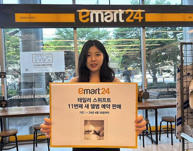 모델이 이마트24 테일러스위프트 앨범 판매를 홍보하고 있다. [이마트24 제공]