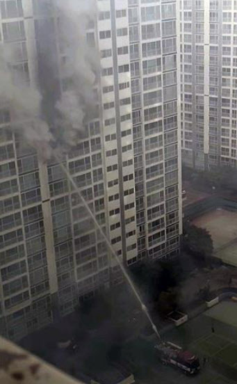 25일 오후 부산 남구 용호동의 한 아파트에 화재가 발생해 진압하는 모습. 연합뉴스