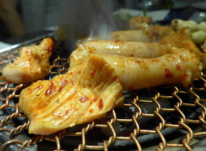 두툼한 구리석쇠 위에서 익어가는 양과 대창. 숯불로 제대로 구워주면 눈, 코, 입을 ‘3연타’하는 저 세상 맛을 선사한다.사진제공｜연타발