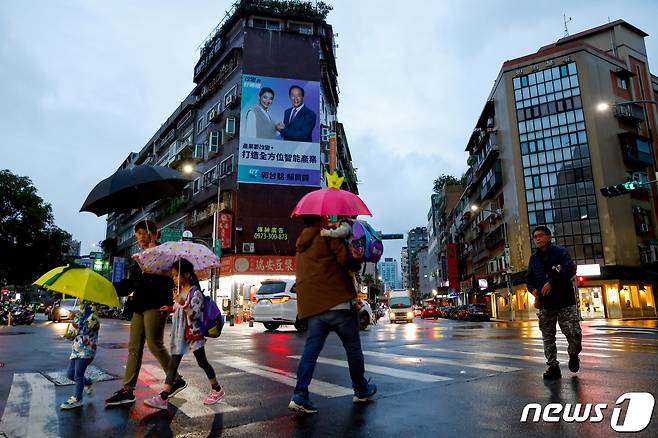 지난달 24일 대만의 수도 타이베이 시민들이 대만 총통 후보 대형 현수막이 걸린 길거리를 지나가고 있다. ⓒ 로이터=뉴스1 ⓒ News1 박형기 기자