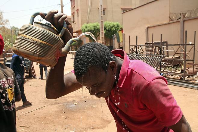 지난 18일(현지시간) 말리 수도 바마코에서 한 남성이 더위를 식히기 위해 머리에 물을 붓고 있다. 이날 바마코 평균 기온은 섭씨 44도를 기록했다. AP연합뉴스