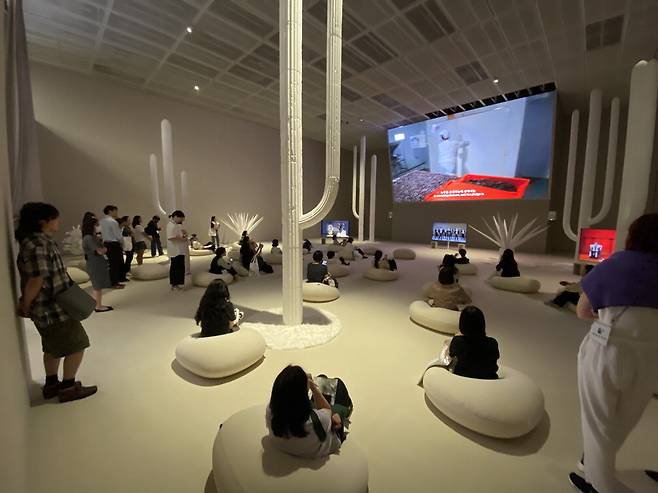 국립현대미술관 서울의 정연두 개인전을 2030 관람객들이 빈백에 누워 편안하게 관람하고 있다.  국립현대미술관