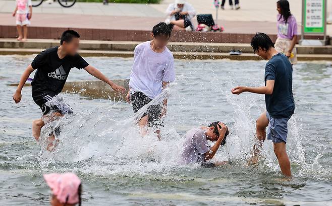 서울 한낮 기온이 28도까지 오르며 초여름 날씨를 보인 28일 오후 서울 영등포구 여의도한강공원 물빛광장에서 학생들이 물놀이를 즐기고 있다. [연합]