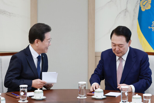 이재명 더불어민주당 대표가 29일 서울 용산 대통령실 집무실에서 열린 윤석열 대통령과의 회담에서 미리 준비해 온 메시지를 품에서 꺼낸 뒤 윤 대통령과 대화하고 있다. 연합뉴스