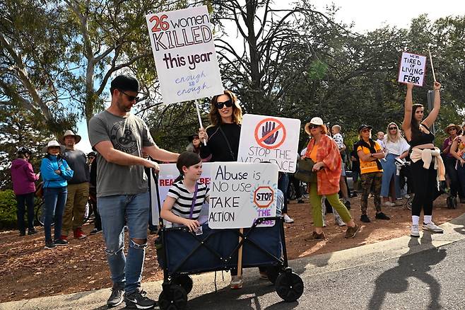 28일(현지시간) 호주 캔버라에서 여성 폭력 근절을 위한 정부 행동을 촉구하는 집회에 참석한 시민들이 팻말을 들고 행진하고 있다. EPA연합뉴스