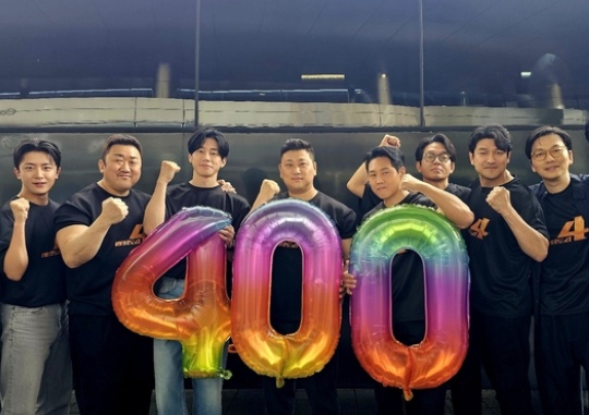 The cast of “The Roundup: Punishment” and director Heo Myung-haeng(center) pose for a photo to celebrate the film\'s 4 million viewers. Courtesy of Plus M Entertainment