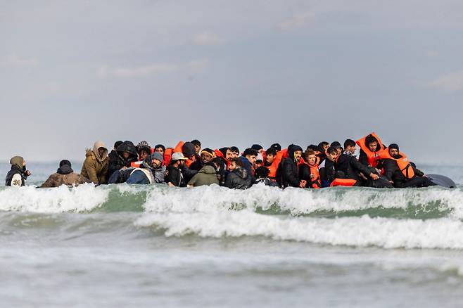 지난 26일(현지시간) 이민자들이 영국 해협을 건너기 위해 프랑스 북부 케르크 인근 그라블린 해변가에 떠 있는 소형보트에 탑승해 있다. AFP연합뉴스