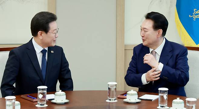 Democratic Party of Korea leader Lee Jae-myung, left, speaks with President Yoon Suk Yeol at the presidential office in Yongsan-gu, central Seoul on Monday. (Yonhap)