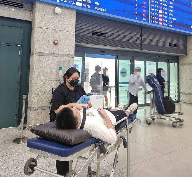 25일 환자이송침대에 실려 인천공항 입국장으로 나오는 백씨. [사진 출처 = 성남시]