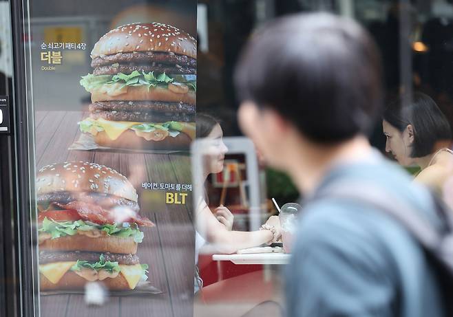 서울 중구 명동 거리 한 음식점에 햄버거 메뉴 사진 안내판이 붙어 있다. [연합]