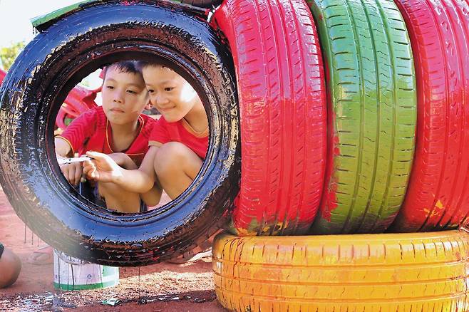 베트남 호아빈성 마이쩌우현에서 진행된 ‘그린라이트 프로젝트’ 활동으로 이뤄진 업사이클 놀이터 조성에 현지 어린이들이 동참하고 있다./굿네이버스 제공