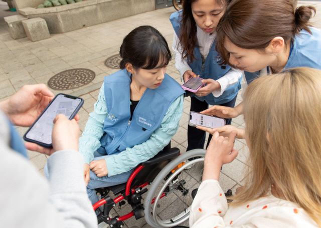 포스코인터내셔널 임직원들이 휠체어를 타고 다니며 휠체어 사용자 입장을 직접 경험하고 휠비(휠체어 전용 네비게이션) 앱에 들어갈 위치 정보를 수집하고 있다. 포스코인터내셔널 제공