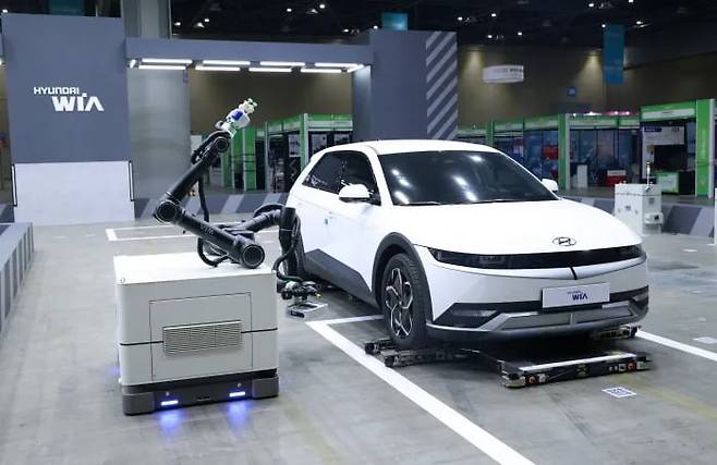 현대위아가 지난해 ‘로보월드 2023’에서 공개한 무인 주차 로봇이 차량 밑에 들어가 차를 이동시키고 있다. 현대위아 제공